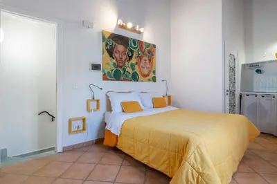 a bedroom with a bed and a painting on the wall at GuestHost - Casetta del Romito - Lovely Studios in Palermo