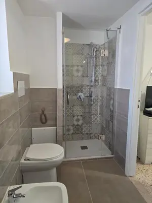 a bathroom with a shower with a toilet and a sink at Mak house in Palermo