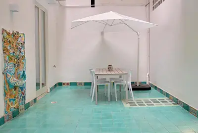 a table and chairs with an umbrella in a room at Palazzo Gregorietti Boutique Apartments in Palermo