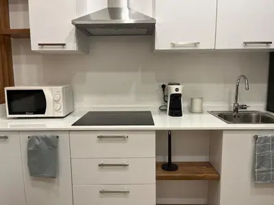 a white kitchen with a microwave and a sink at A Casa di Chiara in Palermo