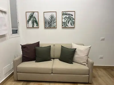 a couch in a living room with four pictures on the wall at A Casa di Chiara in Palermo