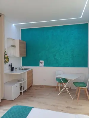 a kitchen with a table and chairs and a blue wall at Carruzzata 2 in Bagheria