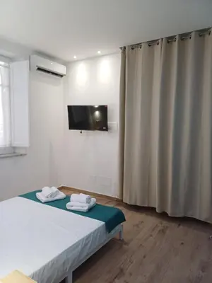 a bedroom with a bed and a tv on the wall at Carruzzata 2 in Bagheria