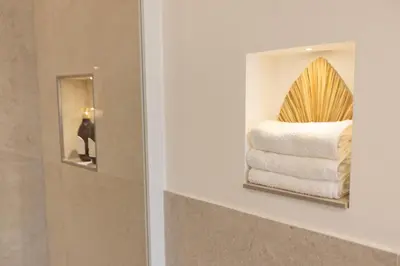 a mirror in a bathroom with a pile of towels at Dimora Blanca in Bagheria