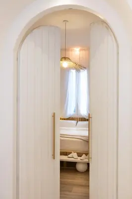 an archway leading to a bedroom with a bed and a window at Dimora Blanca in Bagheria
