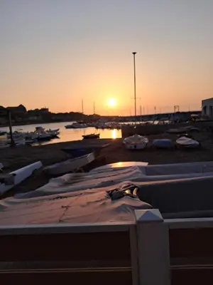 a sunset over a marina with boats in the water at House victor in Palermo