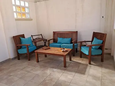 a room with three chairs and a table with blue pillows at House victor in Palermo