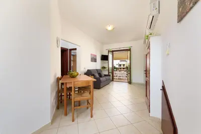 a living room with a wooden table and a dining room at Trilocale 4 moderno con patio a San Vito Lo Capo in San Vito lo Capo