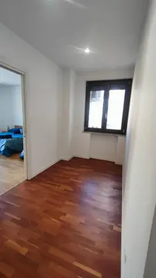 an empty room with a wooden floor and a window at utveggio view apartment in Palermo