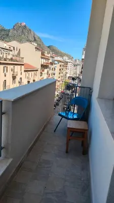 a blue chair sitting on top of a balcony at utveggio view apartment in Palermo
