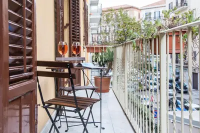 a balcony with two glasses of wine on a table at Casa Soliva al Centro di Palermo in Palermo