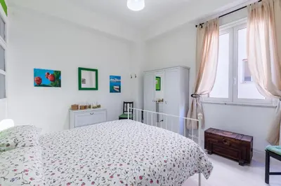 a white bedroom with a bed and a window at Casa Soliva al Centro di Palermo in Palermo