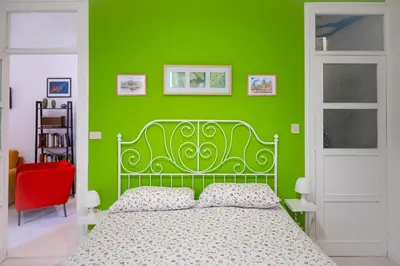 a green bedroom with a bed and a green wall at Casa Soliva al Centro di Palermo in Palermo