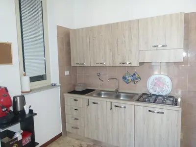 a kitchen with wooden cabinets and a sink at Casa di Laura - Aspra vista mare in Bagheria