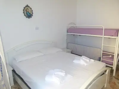a bed with white sheets and white pillows in a room at Casa di Laura - Aspra vista mare in Bagheria