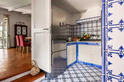 a kitchen with blue and white tiles on the walls at Solemar Sicilia - Villa Mondello in Palermo
