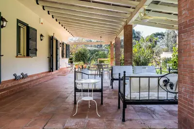 a patio with tables and chairs and awning at Solemar Sicilia - Villa Mondello in Palermo