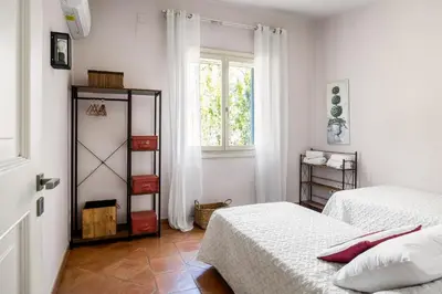 a white bedroom with two beds and a window at Solemar Sicilia - Villa Mondello in Palermo