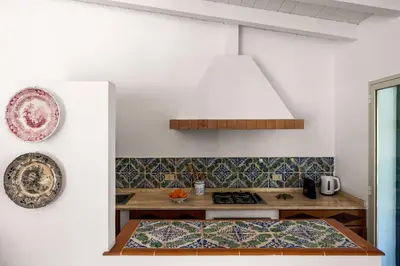 a kitchen with a stove and a plate on the wall at Solemar Sicilia - Villa Mondello in Palermo