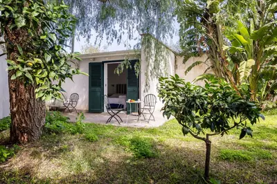 a patio with chairs and a table in a yard at Solemar Sicilia - Villa Mondello in Palermo