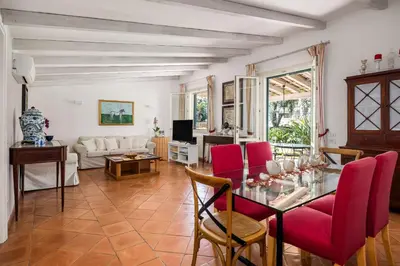 a living room with a glass table and red chairs at Solemar Sicilia - Villa Mondello in Palermo