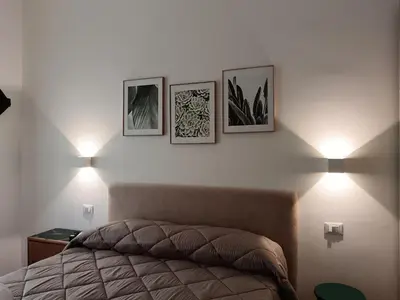 a bedroom with three pictures on the wall and a bed at Calderai 52 Apartments in Palermo