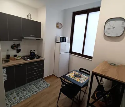 a kitchen with a table and a clock on the wall at Calderai 52 Apartments in Palermo