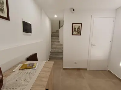 a room with a table and a hallway with stairs at Calderai 52 Apartments in Palermo