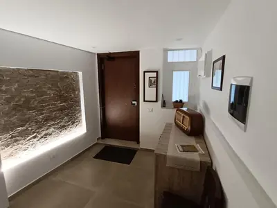 a room with a hallway with a door and a television at Calderai 52 Apartments in Palermo