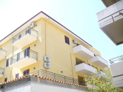 a yellow building with balconies on a building at Appartamenti Campo in Trappeto