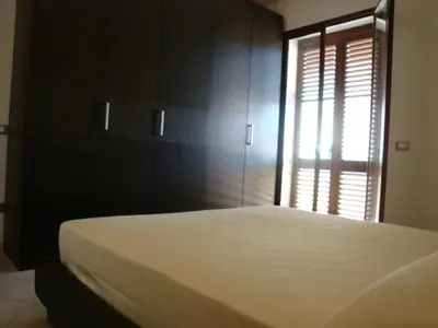 a bedroom with a large bed and a window at Appartamenti Campo in Trappeto