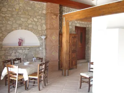 a patio with a table and chairs and a palm tree at Antico Casale Siciliano in Balata di Baida