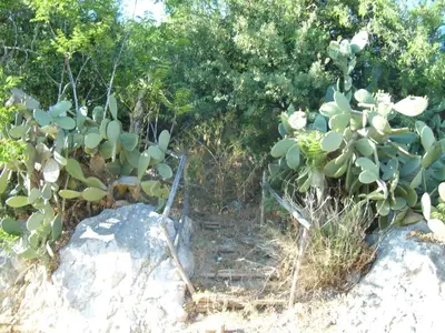 a dining room with a stone wall and a table and chairs at Antico Casale Siciliano in Balata di Baida