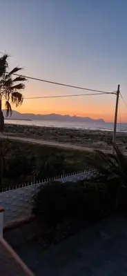 a view of the beach at sunset with a fence at Arancina Abbronzata in Balestrate