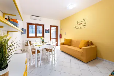 a living room with a couch and a table at Bilocale Piano Terra a 400 mt dal mare in San Vito lo Capo