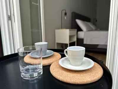 a table with two plates and cups and a glass at Casa Calucca Barrilaio in Palermo