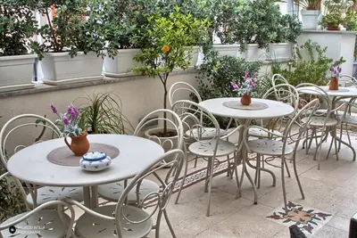 a row of tables and chairs with plants at TAM Vacanze B&B in Cinisi