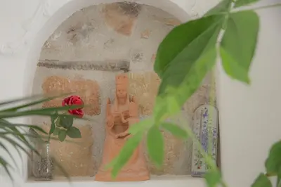 a small statue of a monk with a red rose at TAM Vacanze B&B in Cinisi