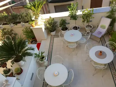 an indoor patio with tables and chairs and potted plants at TAM Vacanze B&B in Cinisi
