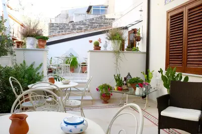 a patio with tables and chairs and plants at TAM Vacanze B&B in Cinisi