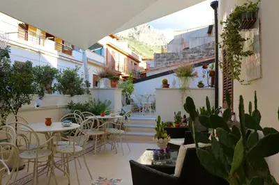 a patio with tables and chairs and potted plants at TAM Vacanze B&B in Cinisi