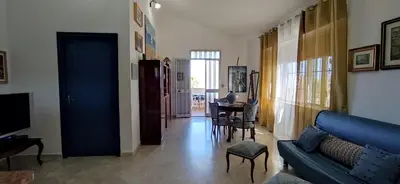 a living room with a blue couch and a table at Gioia Guesthouse in Alcamo