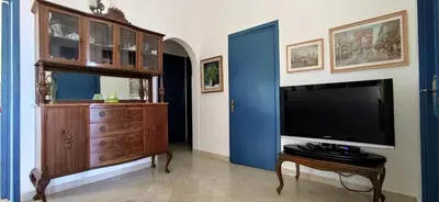 a living room with a large television and a dresser at Gioia Guesthouse in Alcamo