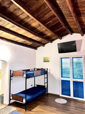 a room with bunk beds and a flat screen tv at Casa Sulla Spiaggia Villa Eléftheria in Altavilla Milicia