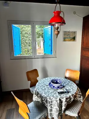 a dining room with a table with blue shutters at Casa Sulla Spiaggia Villa Eléftheria in Altavilla Milicia