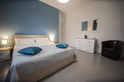 a bedroom with a large bed with two blue pillows at Casa Pisani 274 in Palermo