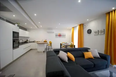 a living room with a couch and a kitchen at Casa Pisani 274 in Palermo