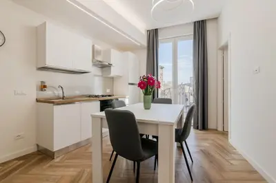 a kitchen and dining room with a white table and chairs at GuestHost - Hamuri Holiday House - Heart of Palermo in Palermo