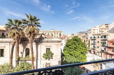 a view of a building with palm trees and buildings at GuestHost - Hamuri Holiday House - Heart of Palermo in Palermo