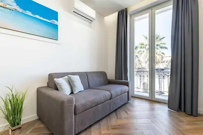 a living room with a couch and a large window at GuestHost - Hamuri Holiday House - Heart of Palermo in Palermo